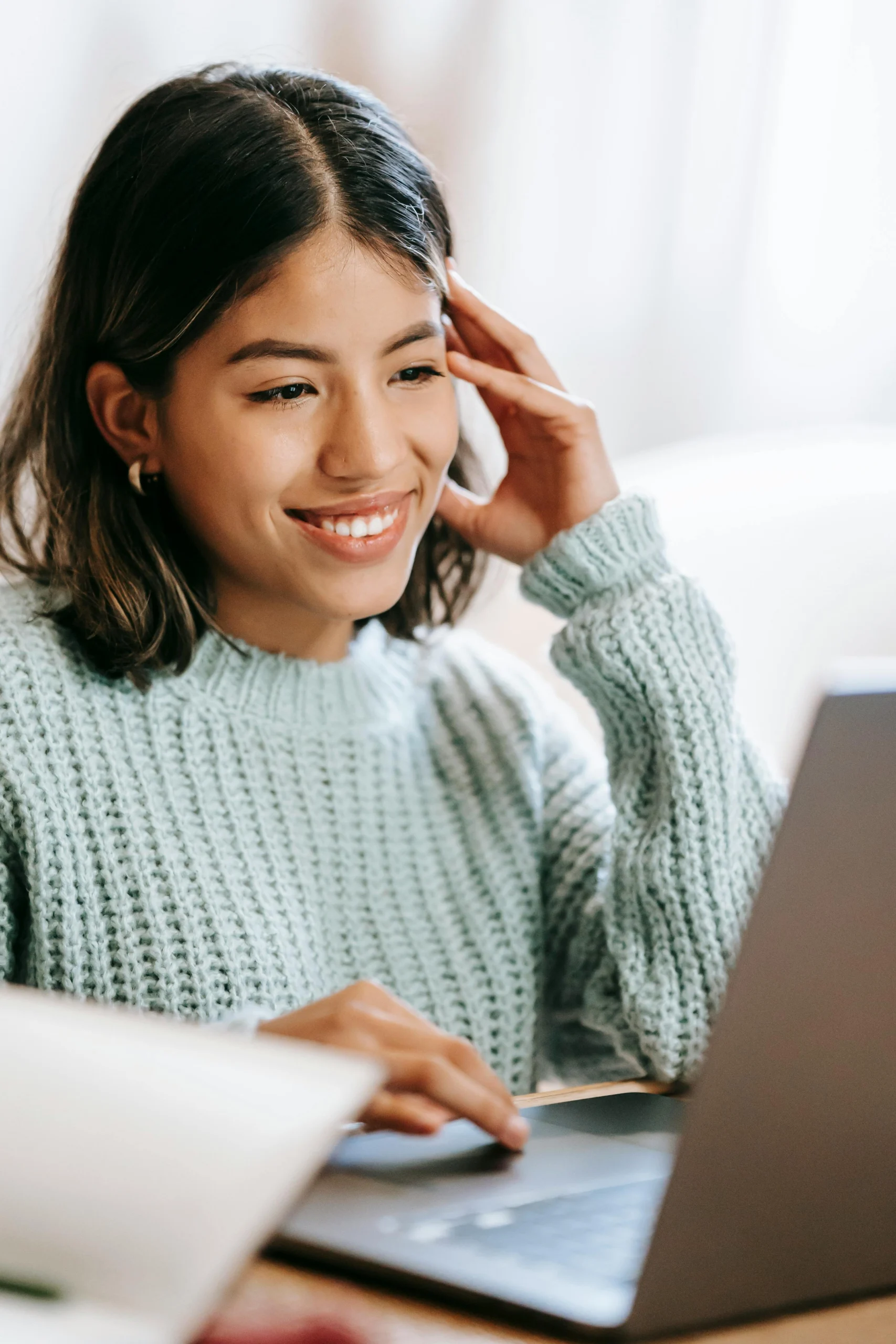 Smiling person using a laptop.