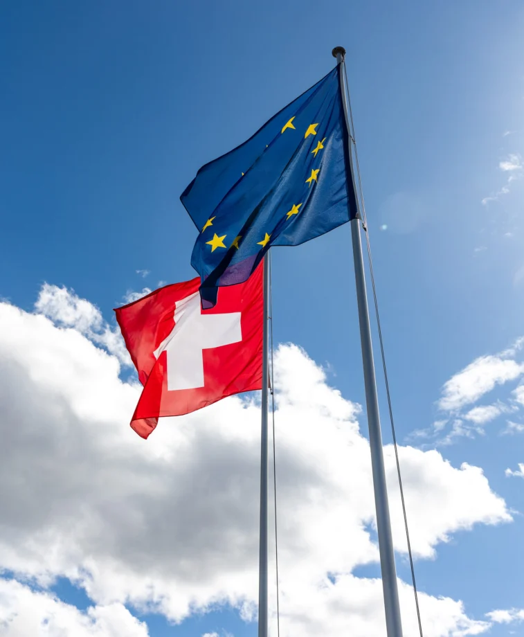 Drapeaux de la Suisse et de l'Union européenne flottant côte à côte.