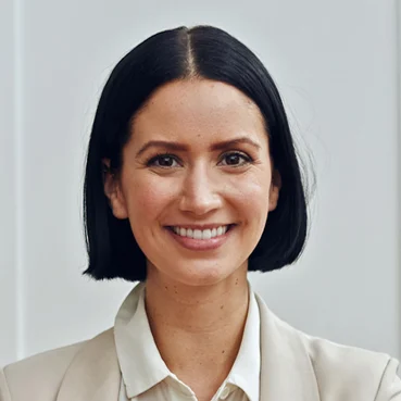Ritratto di una donna sorridente con un blazer chiaro.