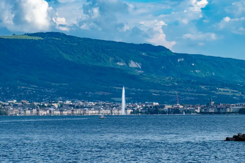 La rade de Genève et le Jet d’eau vus depuis le lac, avec la ville et le Salève en arrière-plan.